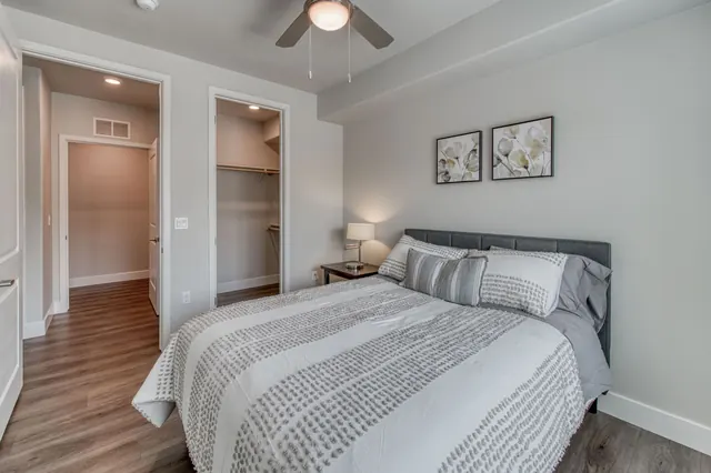 Bedroom with a ceiling fan and doors to the closet and bath