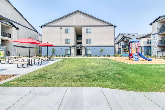 Courtyard lawn with red umbrellas and a playground