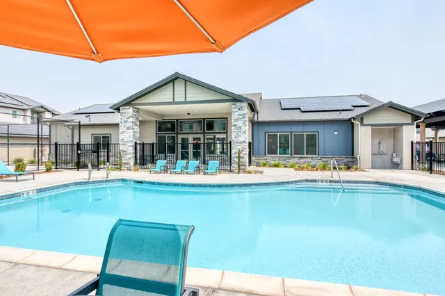 Pool and clubhouse under an orange shade umbrella