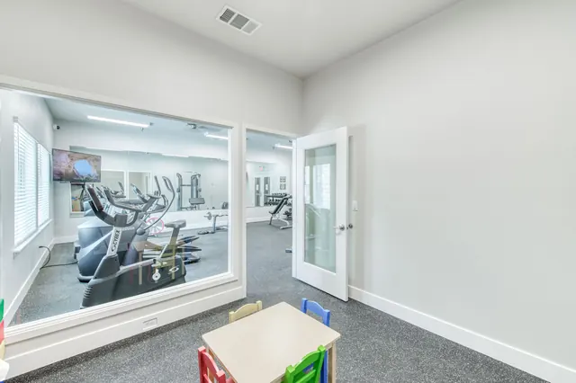 Fitness center treadmills with the children's area behind glass